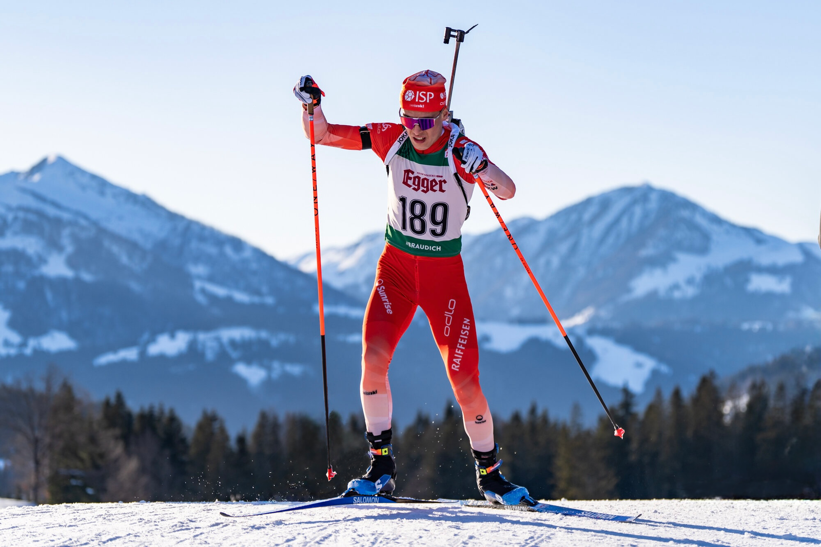 Paul Stalder en course, sur neige, devant les montagnes